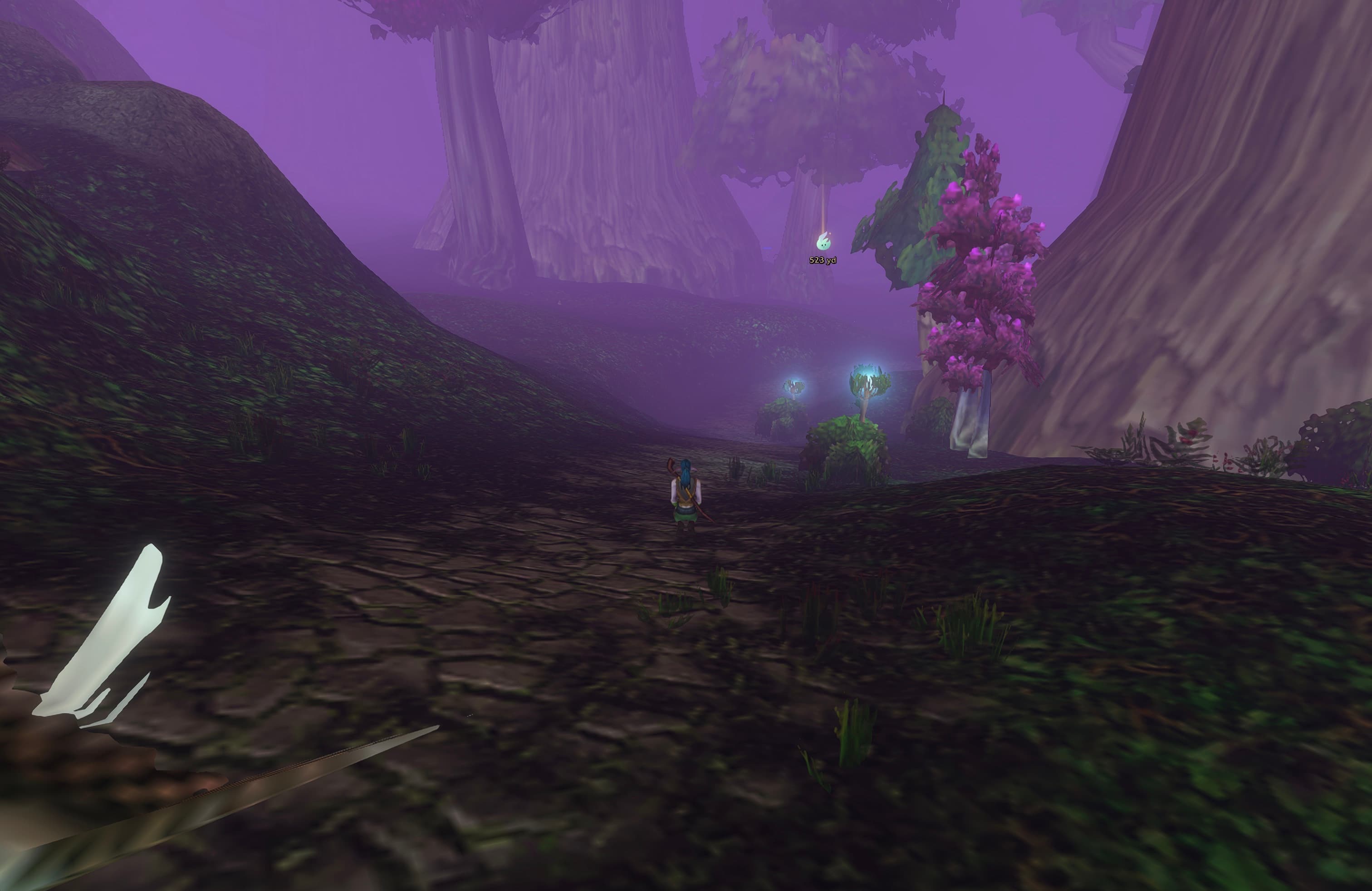 A small Wisp beacon sits farther up the forest path, above and to the right of the character, showing 523 yards.